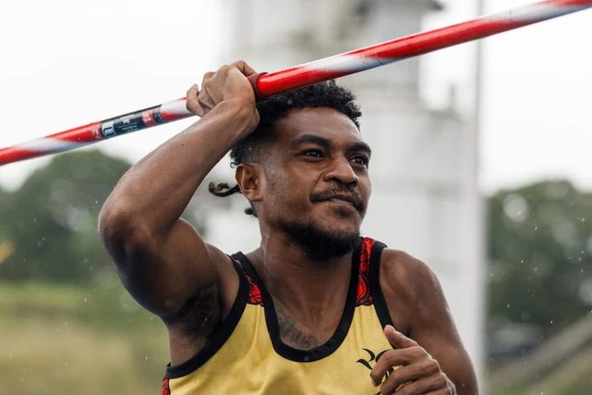 A Papua New Guinean para athlete is preparing to throw a javelin during competition. 