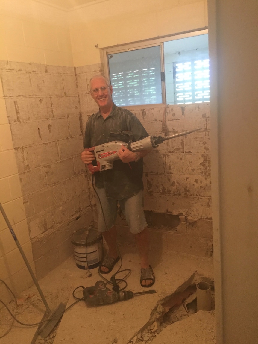 a man with building equipment stands in a renovated house