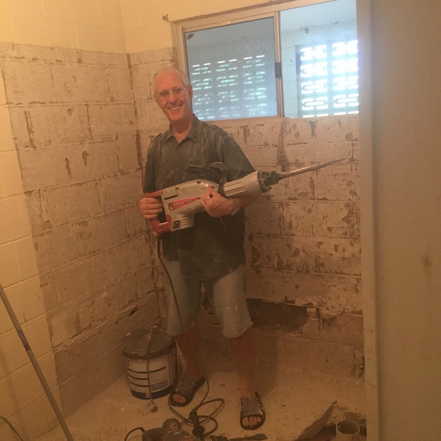 a man with building equipment stands in a renovated house