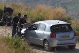 Israeli forensic police inspect the victims' car.
