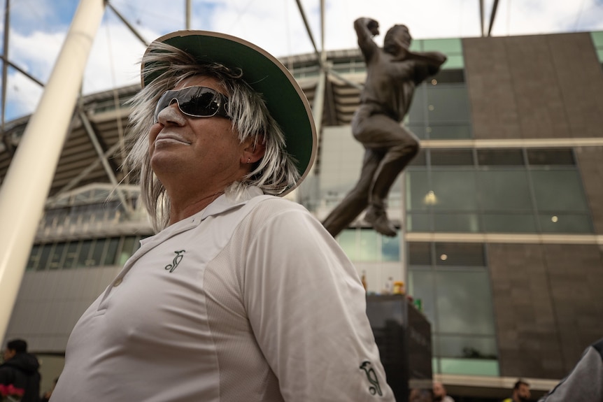 A man dressed as Shane Warne with a wide-brim hat and zinc.