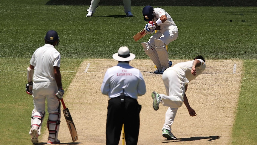 Mitchell Johnson of Australia bowls the ball and hits Virat Kohli of India on the helmet during day three of the First Test match between Australia and India at Adelaide Oval