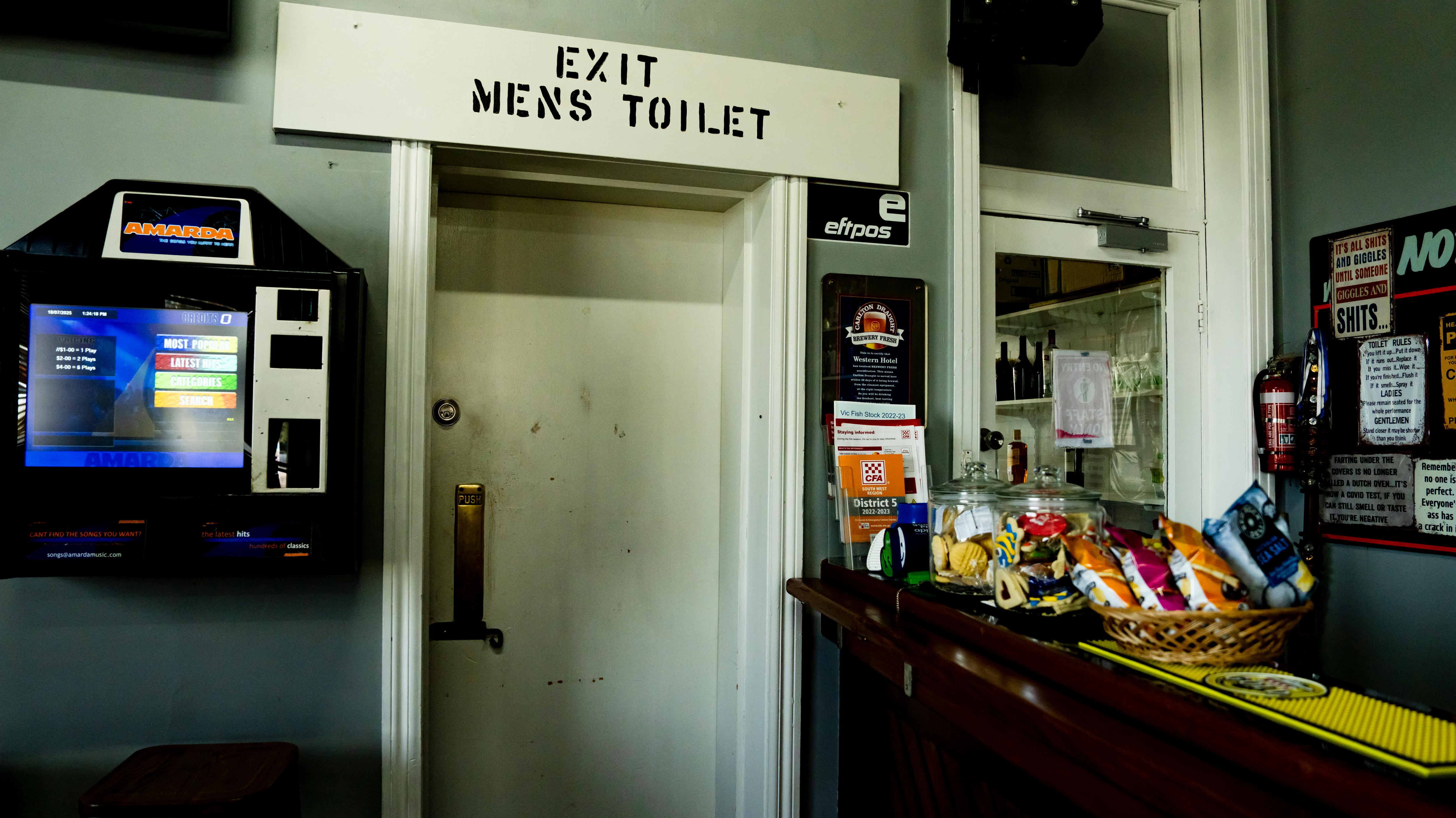 A pub with a door that says Exit Men's Toilets above it.