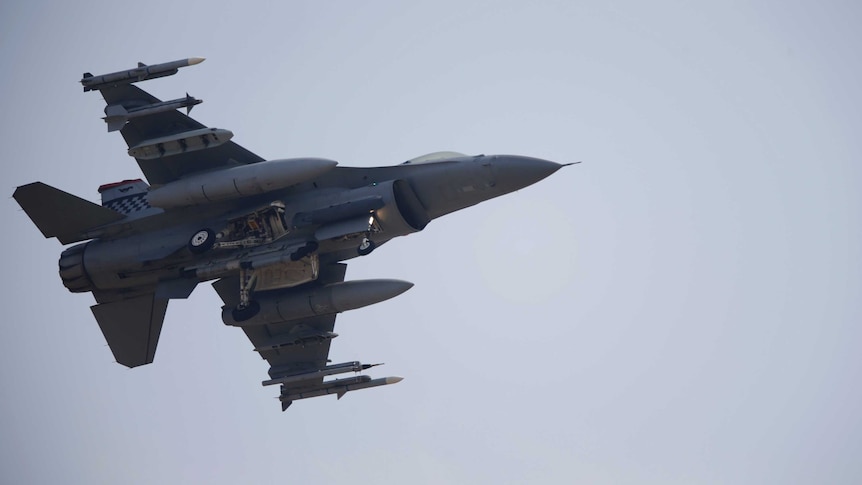 A view from under an F-16 fighter jet as it comes in to land.