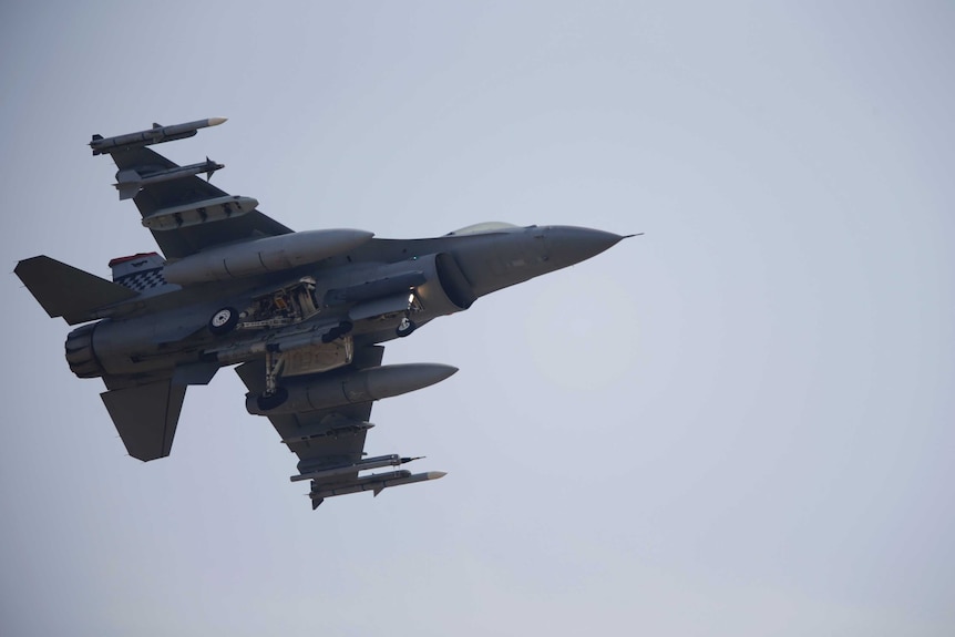 A view from under an F-16 fighter jet as it comes in to land.