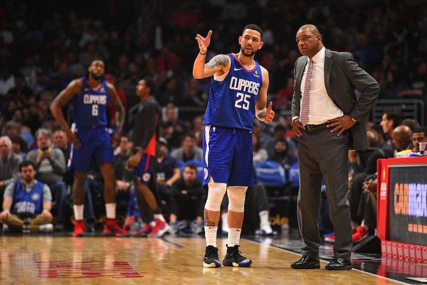 Austin Rivers talks to Doc Rivers during an LA Clippers NBA game.