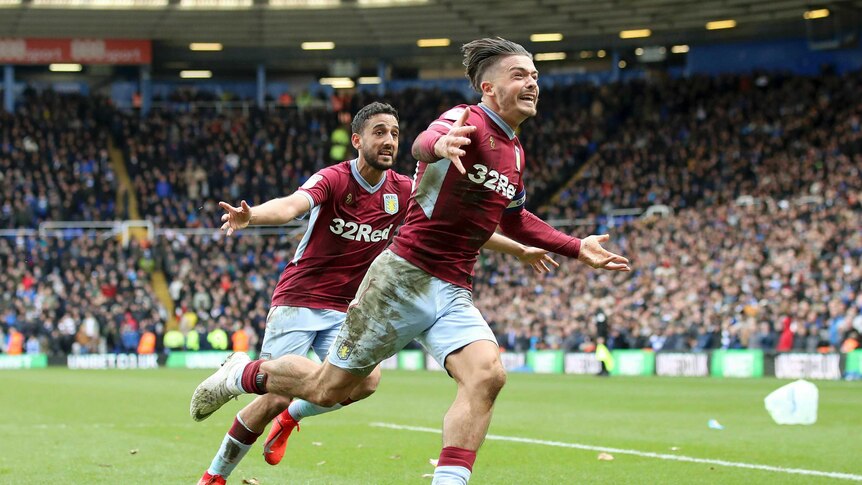 Jack Grealish runs with his arms outstretched