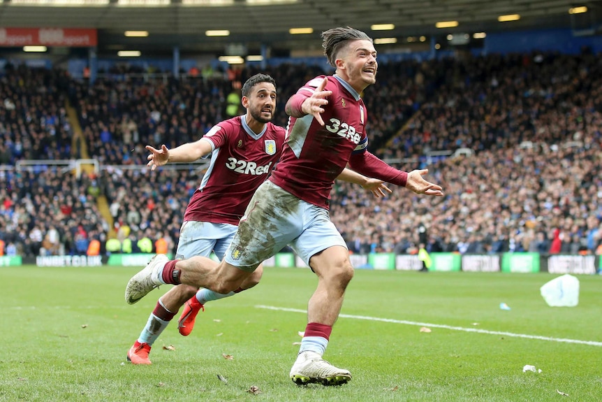 Jack Grealish runs with his arms outstretched