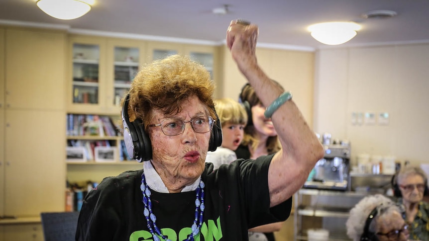 Woman wearing headphones with fist raised