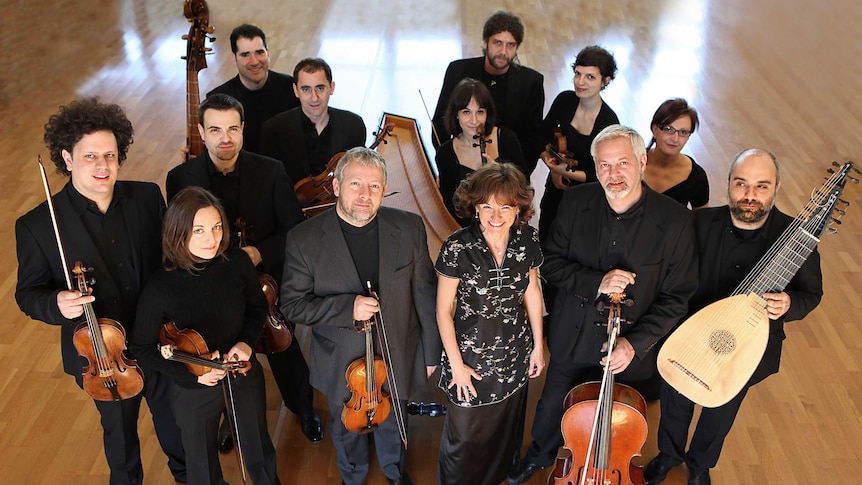 A photograph of Italian baroque ensemble Europa Galante, with members holding their instruments.