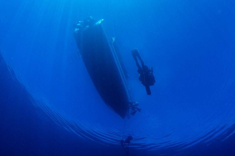 Photo looking up to diver and boat, from dive photographer Damien Siviero website.
