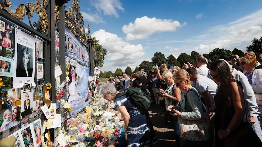 People crowd around the gates of Kensington Palace in London to pay tribute to the late Diana.