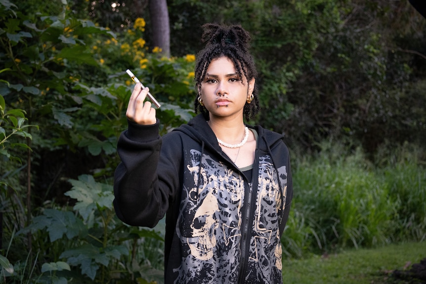 A woman holds a vape