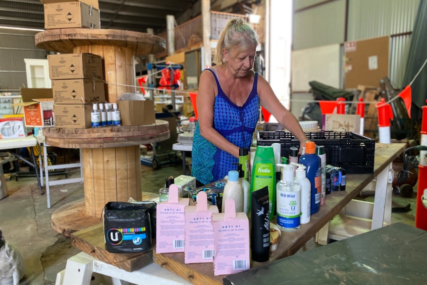 Woman organises bottles of soap and shampoo