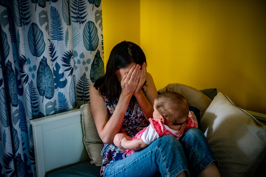 Jennelle covers her eyes during a game of "peek-a-boo" with her baby Rosie.