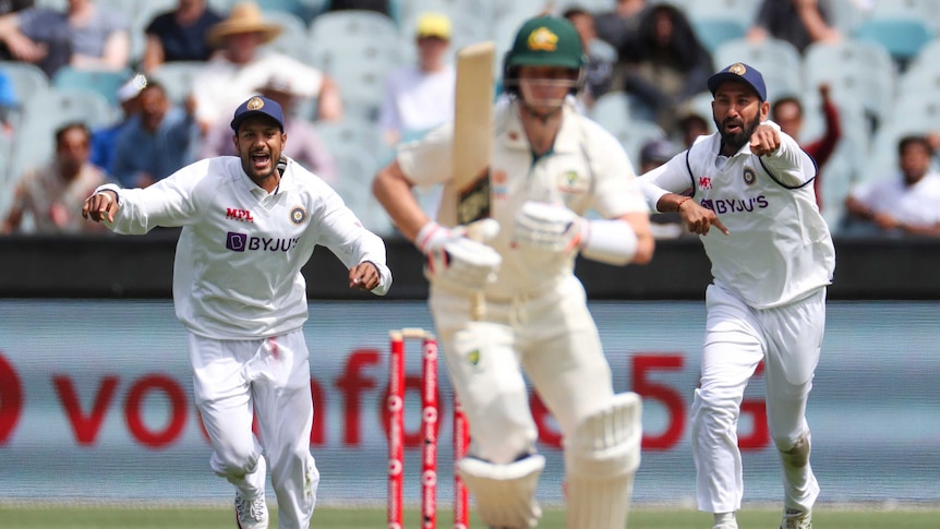 India fielders Mayank Agarwal and Cheteshwar Pujara point and shout as Australia batsman Steve Smith looks to take off for a run