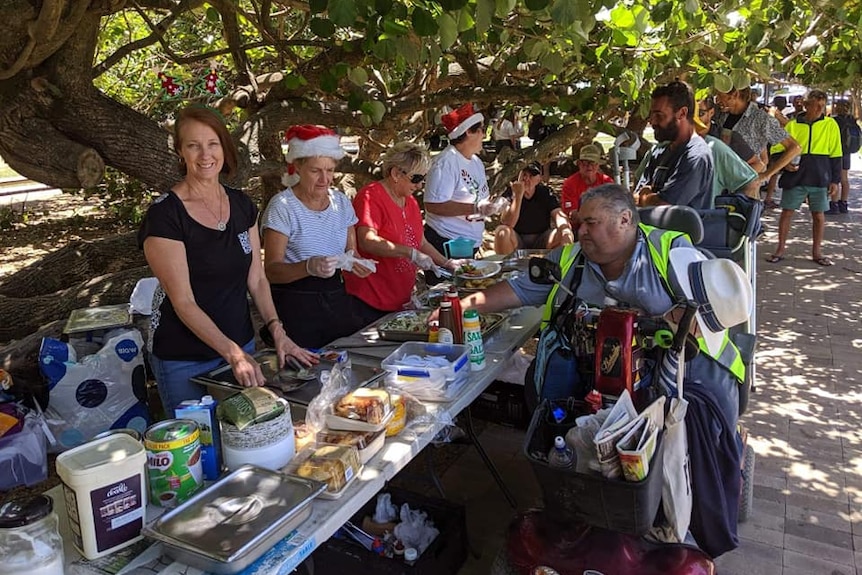 People dish up food for the needy in a park on the Gold Coast.