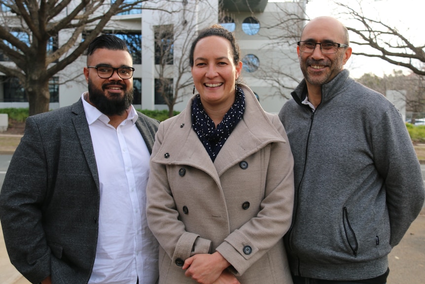 Harry Williams, Ian Hamm and Fiona Cornforth standing outdoors and smiling at the camera.