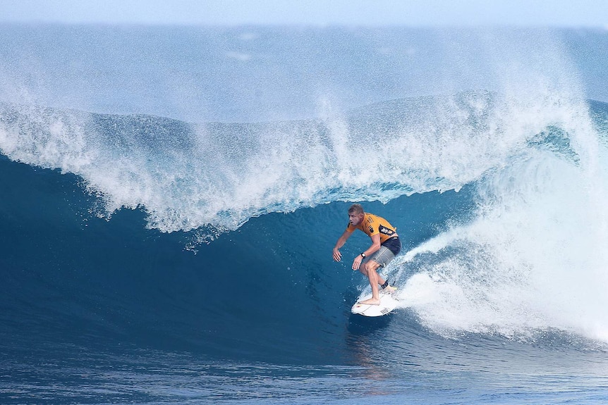 Mick Fanning crouches low as he enters the pipe that won him the quarter-final over Kelly Slater.