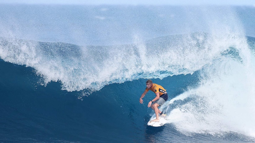 Mick Fanning crouches low as he enters the pipe that won him the quarter-final over Kelly Slater.