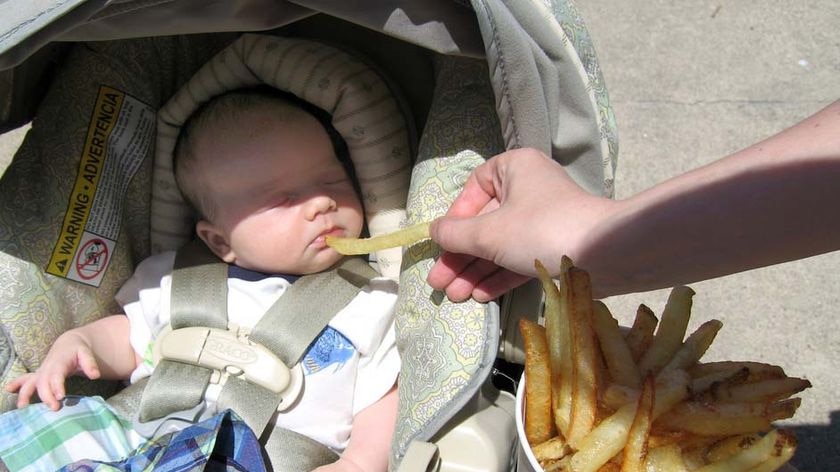 A parent feeds their baby hot chips