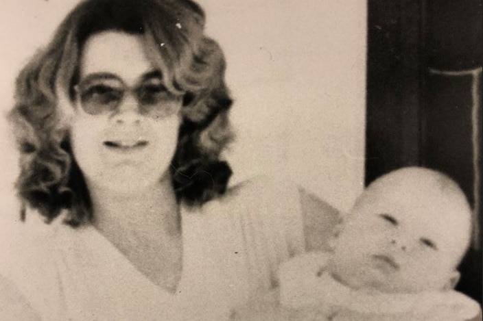 Woman wearing sunglasses standing with her baby