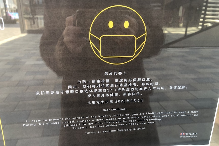 A sign at the Taikoo Li shopping mall in Beijing asks shoppers to wear a mask to prevent the spread of coronavirus.