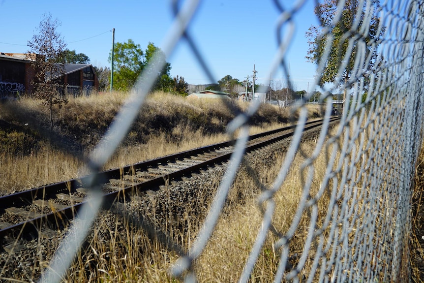The railway line through Kempsey in New South Wales is bordered by a wire fence.