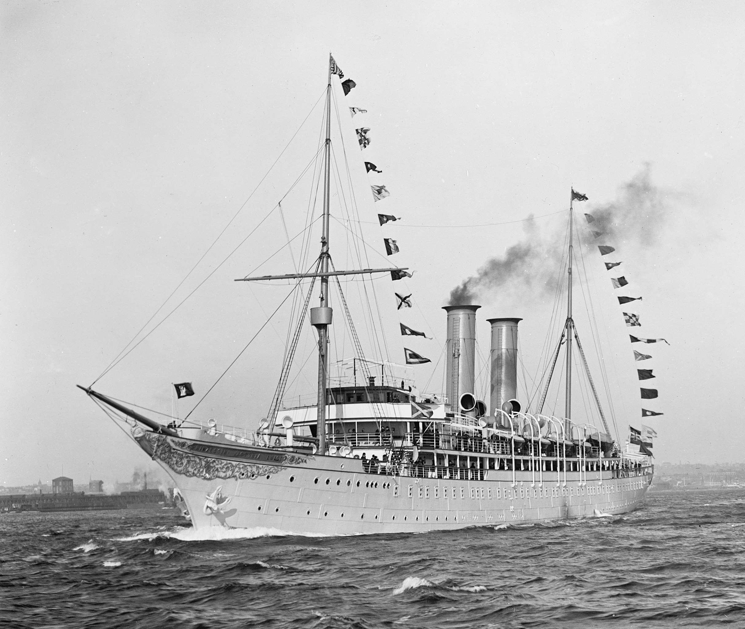 A black and white photo shows the SS Prinzessin Victoria Luise with its pointy wooden bow, and flags draped from its masts.