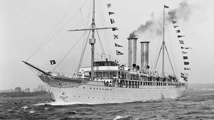 A black and white photo shows the SS Prinzessin Victoria Luise with its pointy wooden bow, and flags draped from its masts.