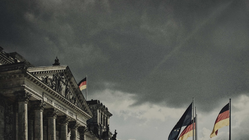 Landscape photo of the Reichstag building with the German flag out the front.
