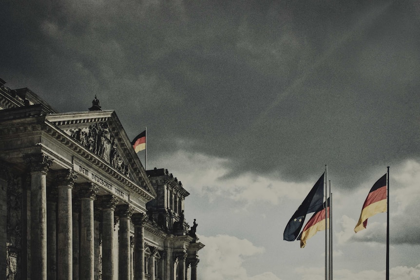 Landscape photo of the Reichstag building with the German flag out the front.