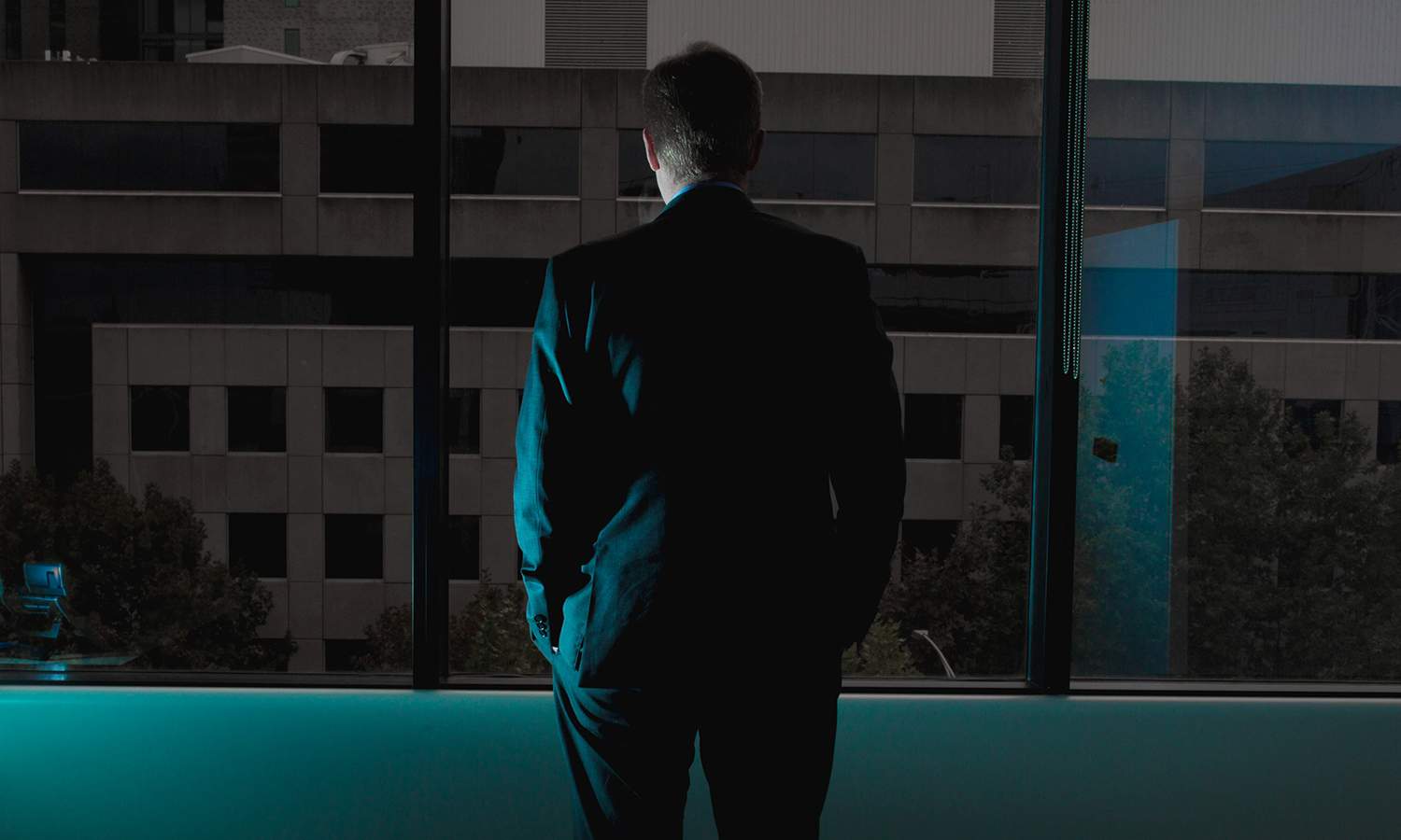 Businessman stares out a window