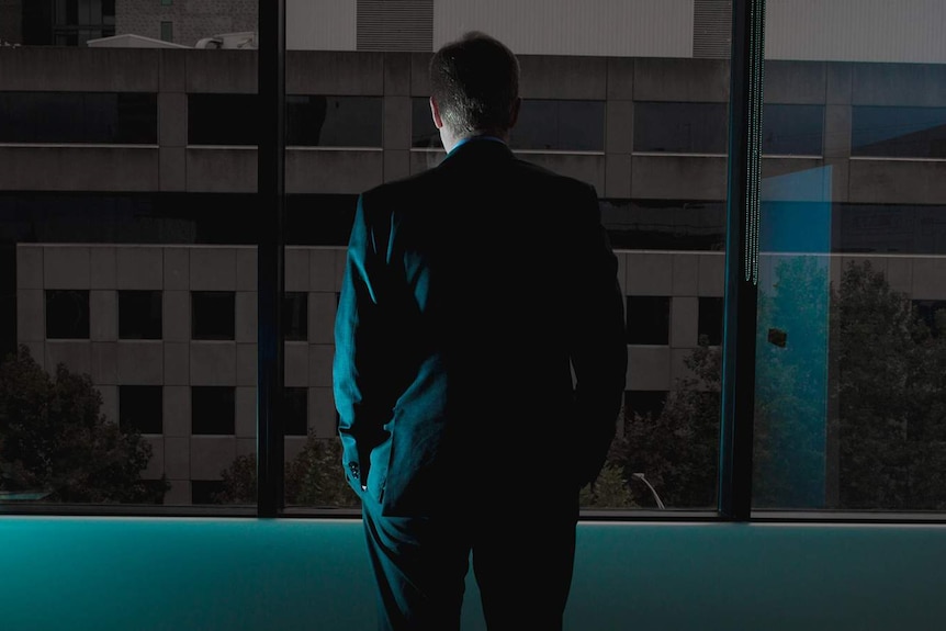 Businessman stares out a window
