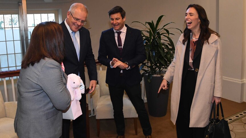 Jacinda laughs as Scott Morrison's wife hands her a gift