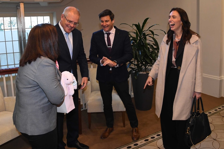 Jacinda laughs as Scott Morrison's wife hands her a gift