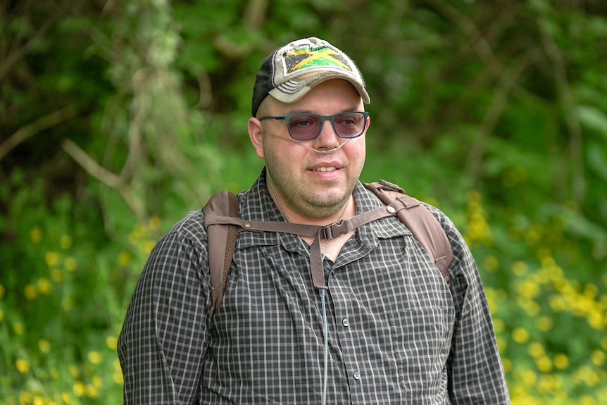 A man in a cap bearing the Jamaican flag looking thoughtfully into the distance