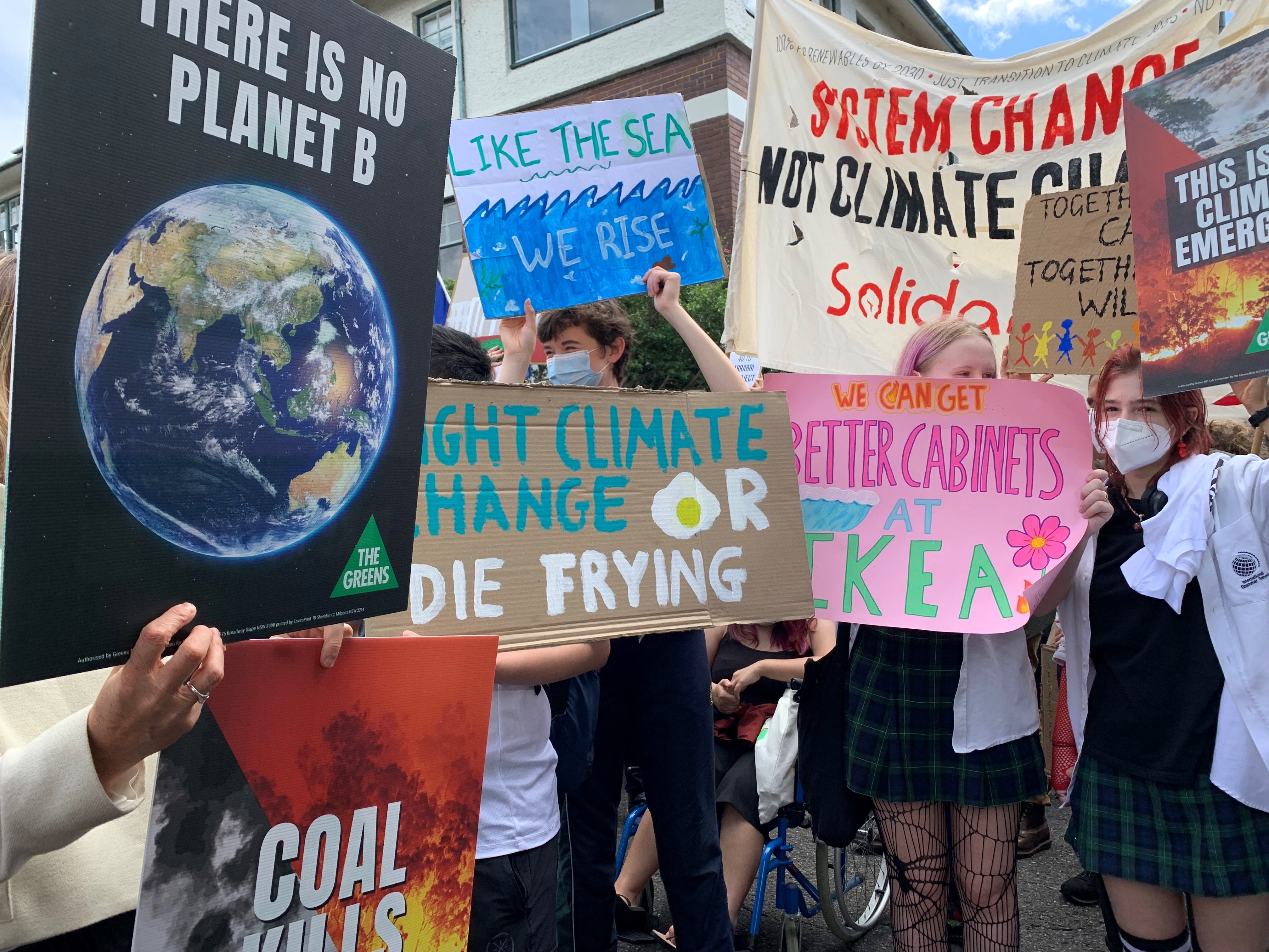 Kids hold signs with slogans calling for action on climate change