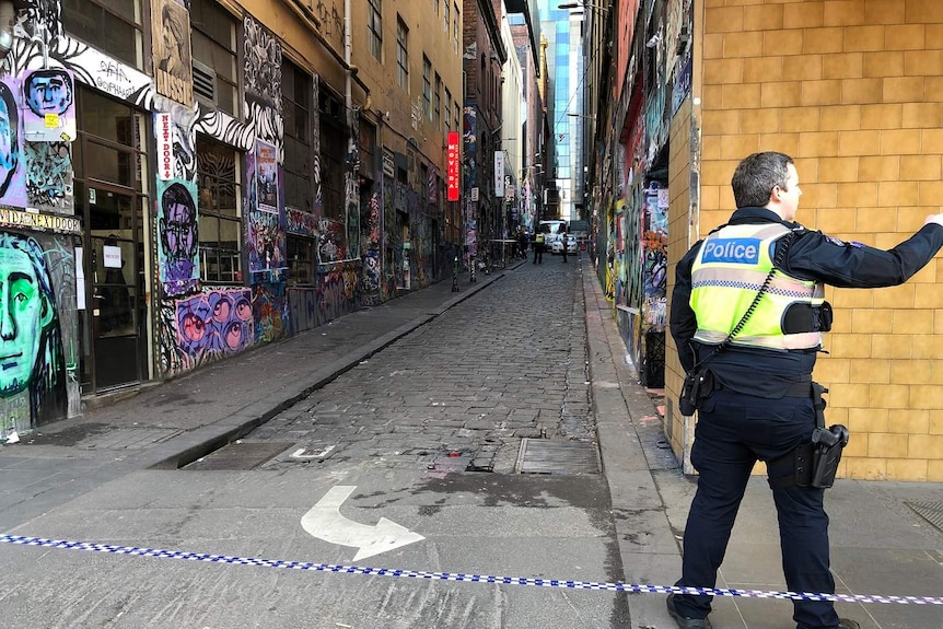 A policeman stands near police tape blocking off the graffiti-covered Hosier Lane in Melbourne.