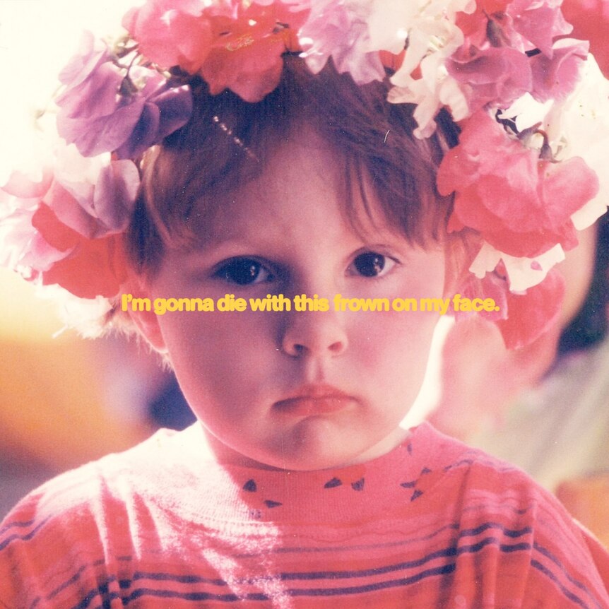 photo of a frowning child wearing a flower crown