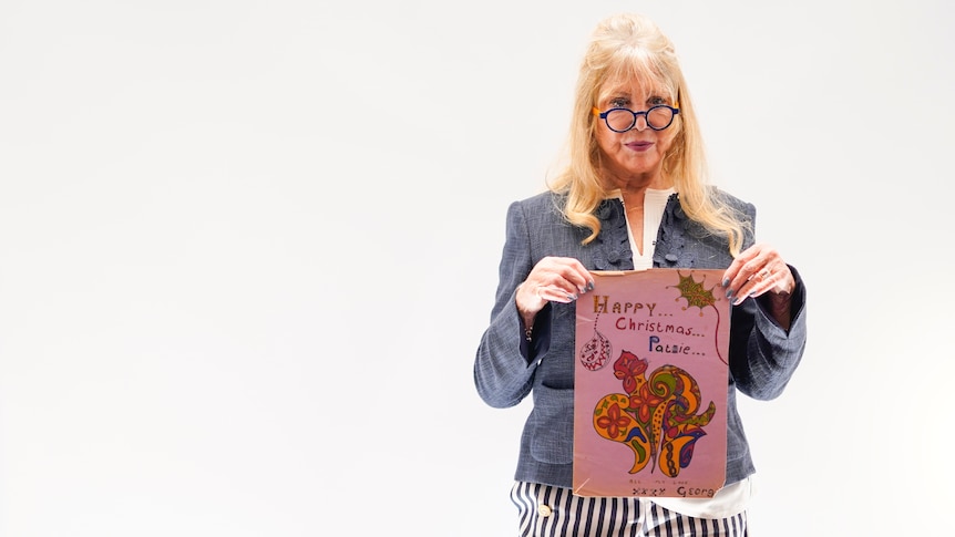 Pattie Boyd holds up Christmas card from George Harrison 