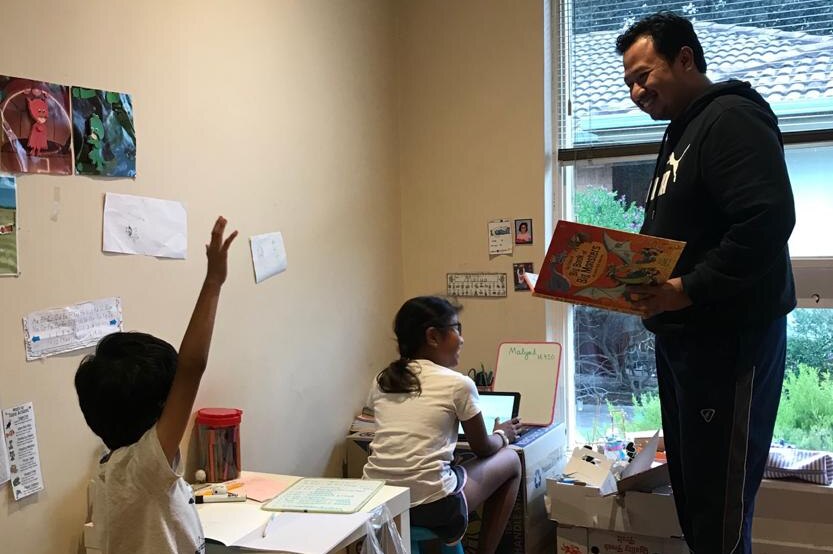 Migrant parent Jamil Bahruddin assists his children learning from home.