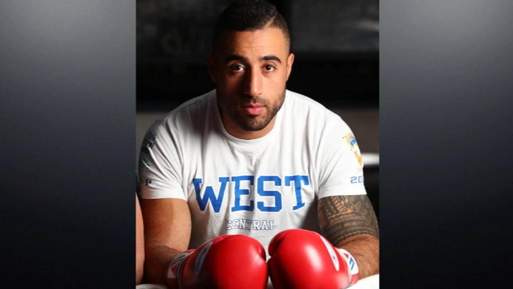 A man wearing boxing gloves and a T-shirt.