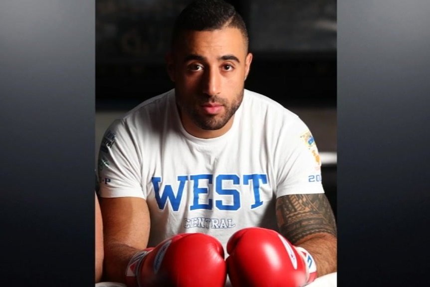 A man wearing boxing gloves and a T-shirt.