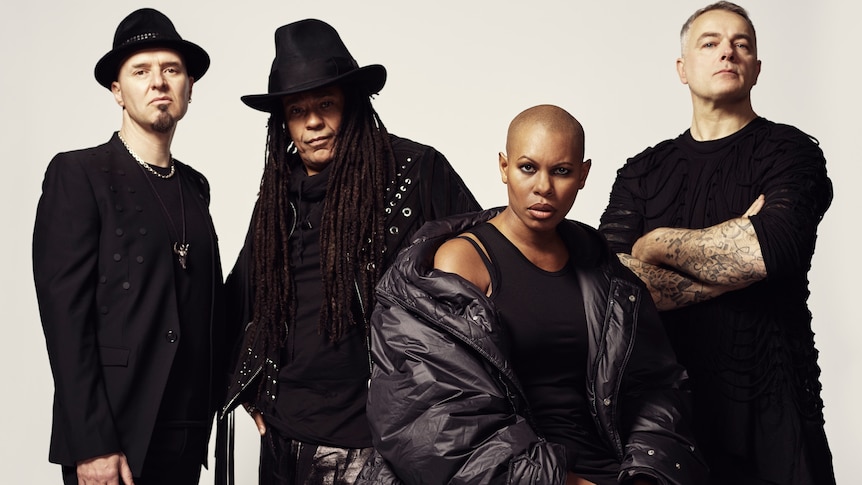 UK rock group Skunk Anansie, four people in front of a white wall. 