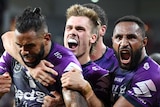 Three Melbourne Storm NRL players embrace as they celebrate a try scored against Parramatta.