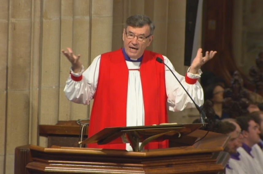 Glenn Davies preaches from a pulpit.