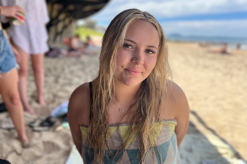 Schoolie, Kelise Beaver sits on Mooloolaba Beach