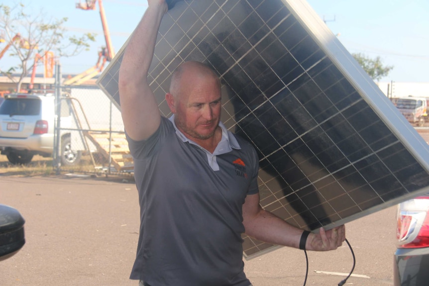 Installer Jeremy Hunt with a broken solar panel that is likely destined for landfill.