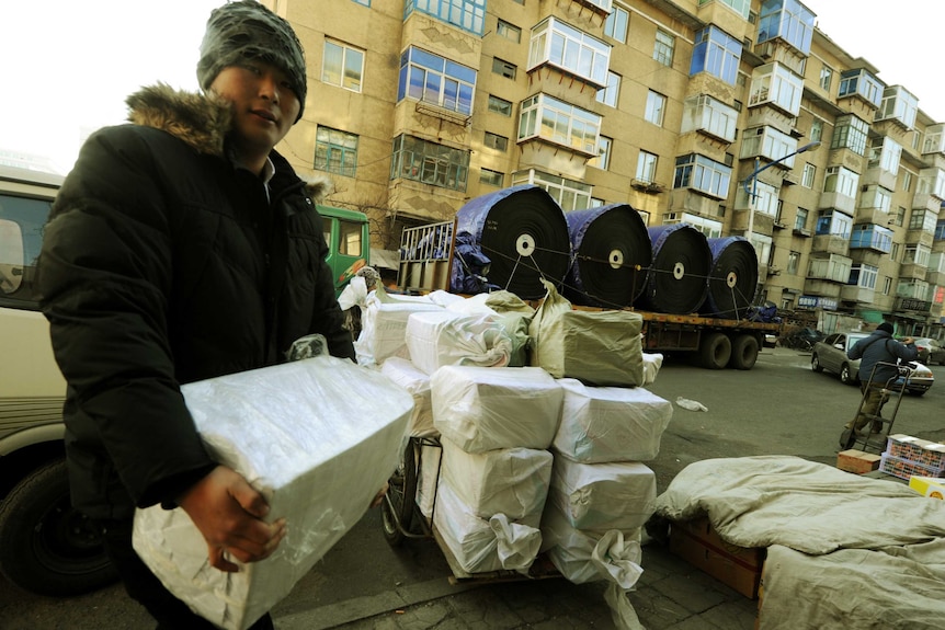 A chinese man loads parcels onto a truck bound for North Korea